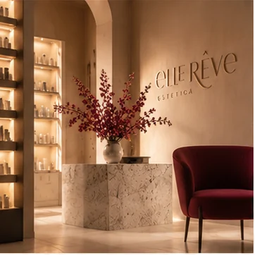 La reception del centro, con il logo Elle Rêve a parete, un vaso di rami fioriti e una poltrona bordeaux